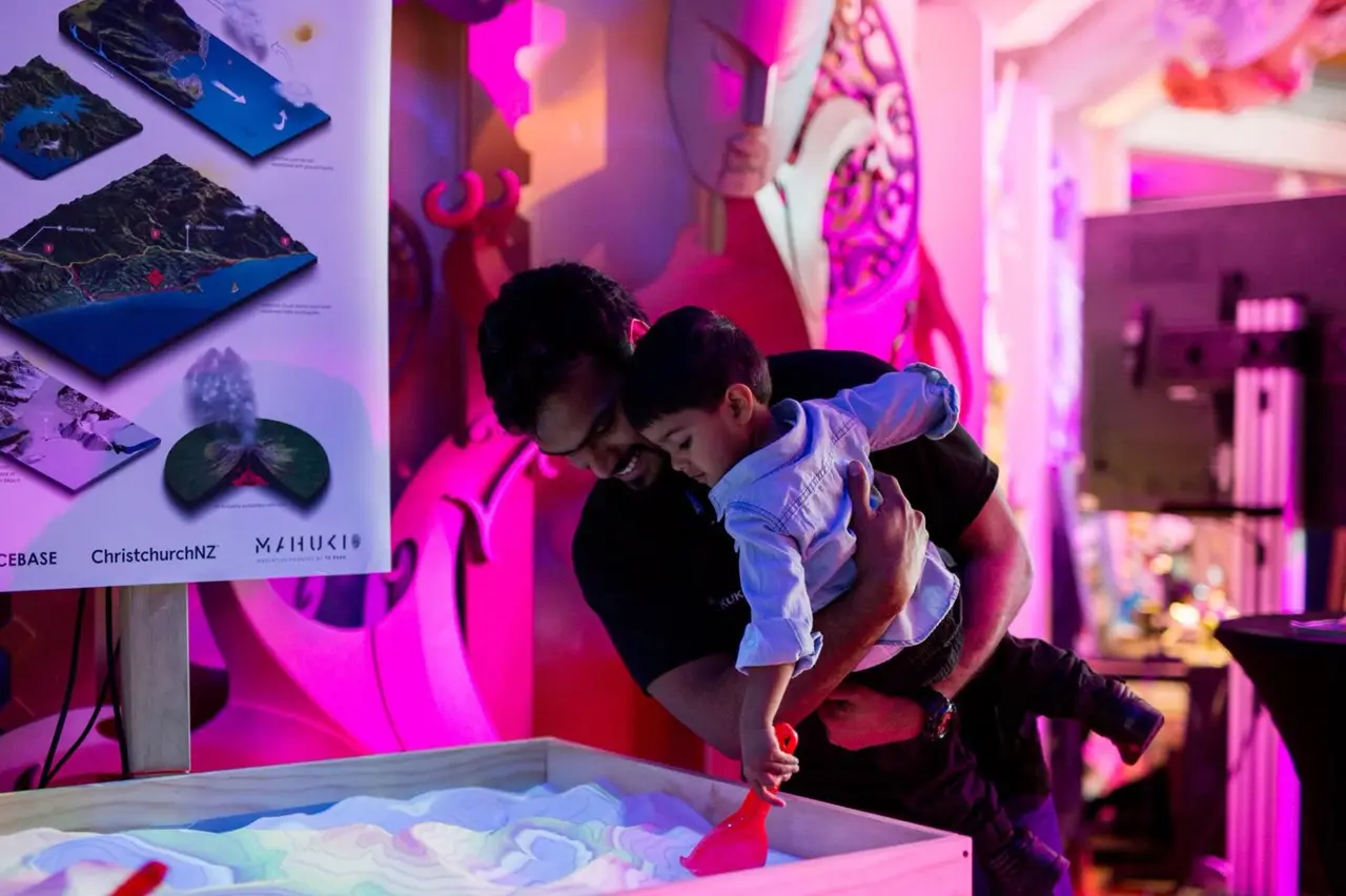 A visitor exploring the AR sandbox on demo day