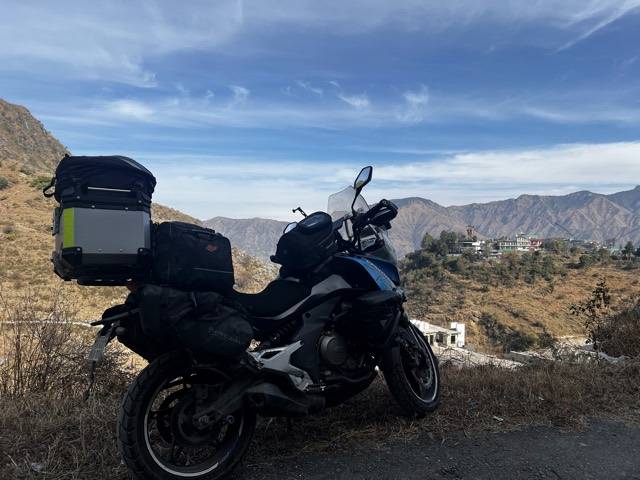 The bike side-on against the Himachal skyline.