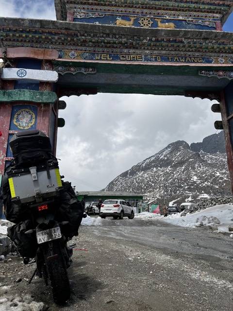 The painted gate at Tawang, Arunachal Pradesh, snow on the ridge behind.